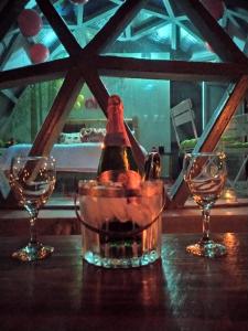 una bottiglia di vino seduta su un tavolo con due bicchieri di Eco Domo glamping ad Armenia