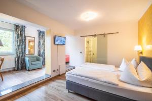 ein Hotelzimmer mit einem Bett und einem Stuhl in der Unterkunft Hotel Schottenhof in Mainz