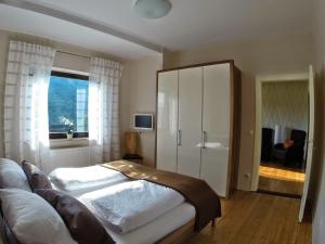 a bedroom with a large white bed and a window at Ferienwohnungen Haus am Würzlaysteig in Lehmen