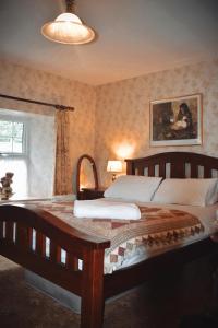 a bedroom with a large wooden bed and a window at Basil Sheils B&B Accommodation Armagh in Armagh
