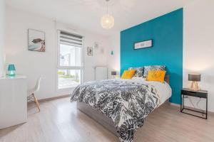een slaapkamer met een blauwe accentmuur en een bed bij Le Merveilleux - Proche Thionville, Metz, Luxembourg in Basse-Yutz