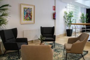a waiting room with chairs and a painting on the wall at Alda Orzán in A Coruña