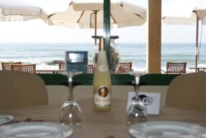 a table with wine glasses and the ocean in the background at Apartamentos La Dorada in La Cala de Mijas