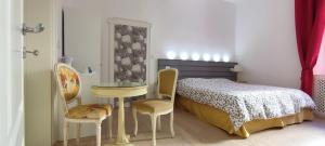 博洛尼亚Strada Maggiore 37的一间卧室，里面有一张床、一张桌子和几把椅子。