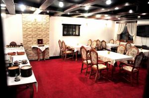 comedor con mesas y sillas y alfombra roja en B&B Sant Bernard en Staré Hory
