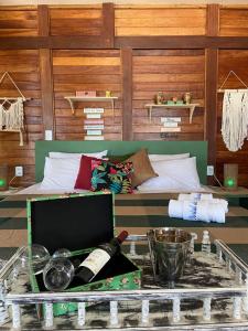 a room with a bed and a table with wine bottles at Pousada Portal do Kite in Tatajuba
