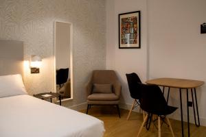 a bedroom with a bed and a chair and a table at Alda Orzán in A Coruña +66 photos