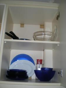 une armoire avec des assiettes et des bols sur une étagère dans l'établissement Konakli Apartments Izmir, à Izmir