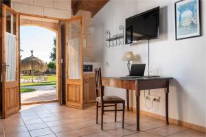 a home office with a desk and a television at Finca Hotel Can Canals & Spa in Campos