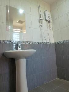 a bathroom with a sink and a shower with a mirror at RELAX HOTEL in Sungai Petani