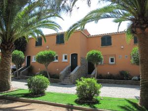 a building with palm trees in front of it at Residence les Bell'ombres in Cargèse