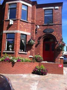 un edificio de ladrillo rojo con una puerta roja y flores en Ashling House Serviced Accommodation en Dublín