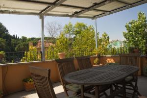 a patio table and chairs on a balcony with a view at Trastevere Belvedere B&B in Rome