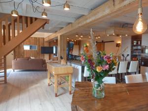 a vase of flowers on a wooden table in a room at Pura Vida Panorama in Oud-Ade