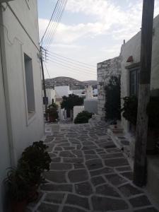 a stone walkway between two buildings in a town at Villa Romantica in Parikia
