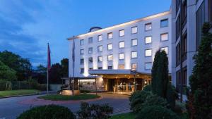 ein großes weißes Gebäude mit einem Gebäude in der Unterkunft AMERON Bonn Hotel Königshof in Bonn