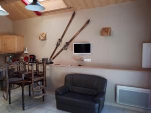 a living room with a chair and a tv at La Michaille in Mijoux
