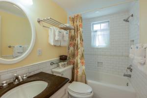 ein Badezimmer mit Waschbecken, Toilette und Spiegel in der Unterkunft Key West Villas in Key West