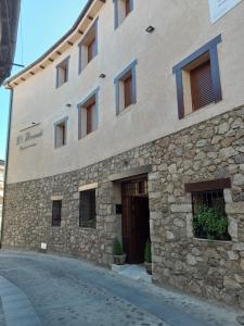 a stone building with a door on the side of it at Apartamentos El Arenal in Acebo
