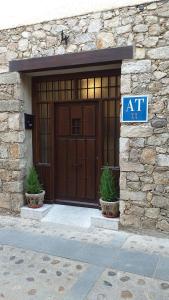 a building with a large wooden door with a sign on it at Apartamentos El Arenal in Acebo