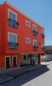 un edificio rojo con ventanas y una bicicleta en la parte delantera en Hotel Santa Cruz, en Chihuahua