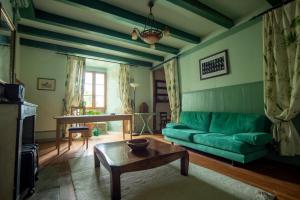 a living room with a green couch and a table at Château de Sothonod in Sothonod
