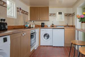 a kitchen with a washing machine and a dishwasher at 1844 Seascape Cottage in Fanore