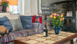 ein Wohnzimmer mit einem Sofa und einer Vase mit Blumen auf dem Tisch in der Unterkunft 1844 Seascape Cottage Is located on the Wild Atlantic Way in Fanore