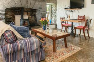 a living room with a table and a fireplace at 1844 Seascape Cottage in Fanore