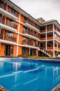 un hôtel avec une piscine en face d'un bâtiment dans l'établissement Alisamay Hotel, à Baños