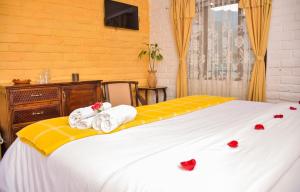 1 dormitorio con 1 cama con toallas en Alisamay Hotel en Baños