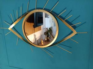 a circular mirror on a blue wall with gold rays at Apartment Close2park *** in Čakovec
