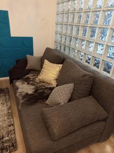a brown couch with pillows in a living room at Apartment Close2park *** in Čakovec