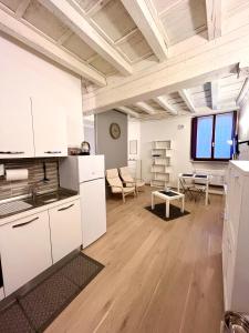 cocina con armarios blancos y sala de estar. en RESIDENZA SERENA SUITE en Mantua