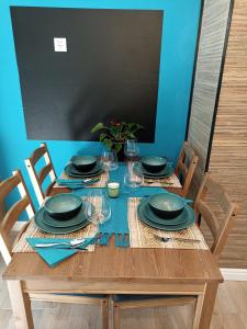a wooden table with plates and glasses on it at Apartment Close2park *** in Čakovec