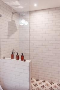 Ein weißes Badezimmer mit zwei Flaschen auf einem Regal in der Unterkunft Ojala in Antigua Guatemala