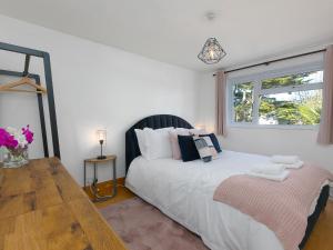 een slaapkamer met een groot wit bed met een raam bij Trengoff in St Ives