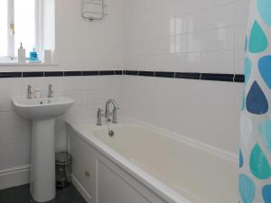 een badkamer met een wastafel en een ligbad naast een wastafel bij Trengoff in St Ives +40 foto's