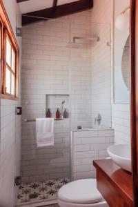 ein Bad mit einer Dusche, einem WC und einem Waschbecken in der Unterkunft Ojala in Antigua Guatemala