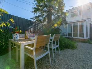 een houten tafel en stoelen in een tuin met een huis bij Trengoff in St Ives