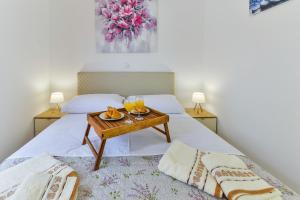 uma cama com uma mesa com dois copos de sumo de laranja em Cascada villas with private jacuzzi and private parking em Starigrad-Paklenica