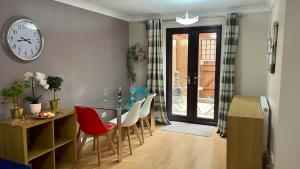 a dining room with a table and chairs and a clock at RiverView 1 Bed Apartment with Parking by CozyNest in Reading