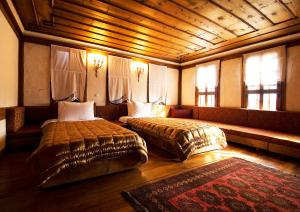 a bedroom with two beds and a couch and windows at Gulevi Safranbolu Heritage Hotel in Safranbolu +280 photos