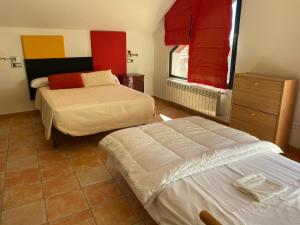 a bedroom with two beds and a dresser and a window at Casa Rural 3 en un fantástico legado in Alfacar