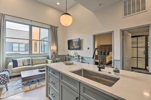 a kitchen with a sink and a living room at Modern Downtown Birmingham Condo with Rooftop Access in Birmingham