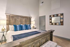 um quarto com uma grande cama de madeira com almofadas azuis em Modern Downtown Birmingham Condo with Rooftop Access em Birmingham