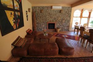 a living room with a leather couch and a table at Kasbah Africa in Ouirgane