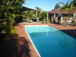 a swimming pool in a yard next to a house at Bomaderry Motor Inn in Nowra