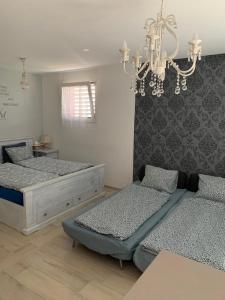 ein Schlafzimmer mit zwei Betten und einem Kronleuchter in der Unterkunft MT's Cosy Place in Dino