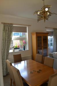 a dining room with a wooden table and chairs at Frinton Escapes - The Cottage in Frinton-on-Sea